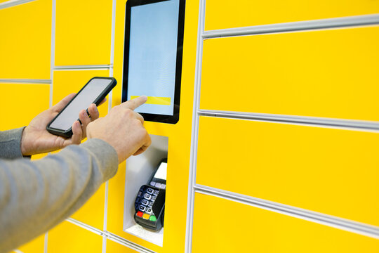 Close up of a man picks up mail from automated self-service post terminal machine