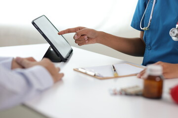 Doctor showing a patient some information on a digital tablet.