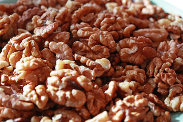 Shelled walnut kernel in plate on kitchen table.
