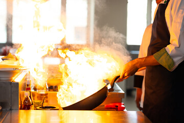 Thai Asian man professional chef cooking meal with fire at kitchen restaurant. culinary classroom....