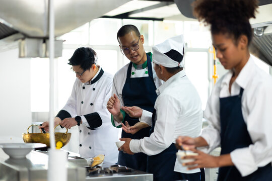 Group of student learning. Cooking class. culinary classroom. group of happy mature man and young woman multi - ethnic students are focusing on cooking lessons in a cooking school.