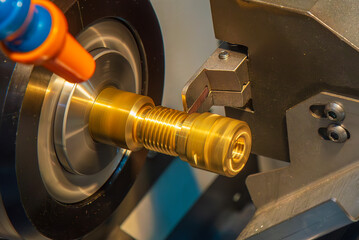 Close up scene the CNC lathe machine slot cutting at the end of brass pipe coupling parts.