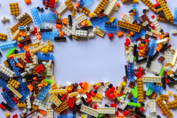 Fototapeta na wymiar pile of colorful Lego blocks with place for content or text. Top angle view of lego bricks on white background. copy space