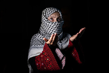 portrait for person praying to allah with white keffiyeh on his face in dark background