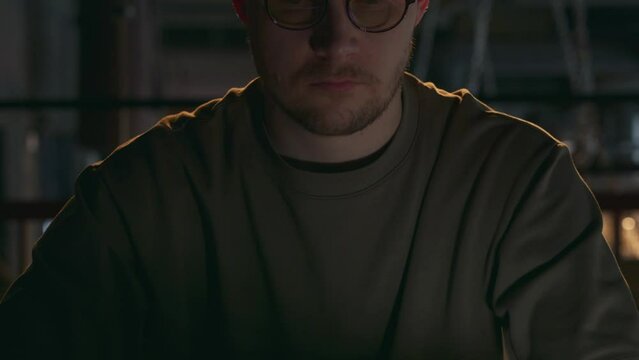 A close-up of a young male cyber criminal closes the laptop screen after another deception on the Internet. The hipster millennial hacker has finished his job. High quality 4k footage