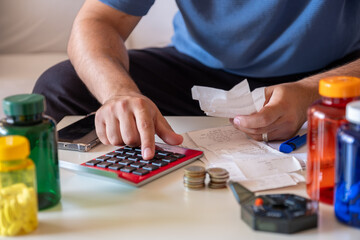 Male calculating costs of medicine while holding receipts