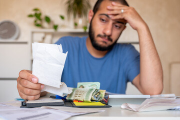 young bearded male callculating living costs in living room