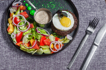 salad nicoise with vegetables and egg, on a plate, tablecloth on the table, dark and moody, top new