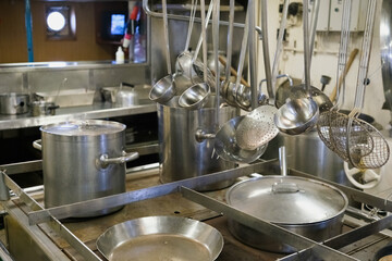 Steel saucepans and casseroles, in an industrial kitchen.