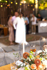Wedding table for guests, decorated with candles, are served with cutlery and crockery and covered with yellow tablecloth