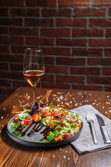 salad with grilled vegetables, roast beef on a black plate, dark and moody, top new