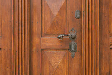 Vintage antique door handle on the old wooden door. Copper keyhole decorative element on weathered...