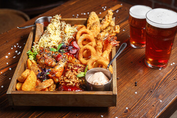 Beer basket with snacks, onion rings, country potatoes, chips, , dark and moody, top new