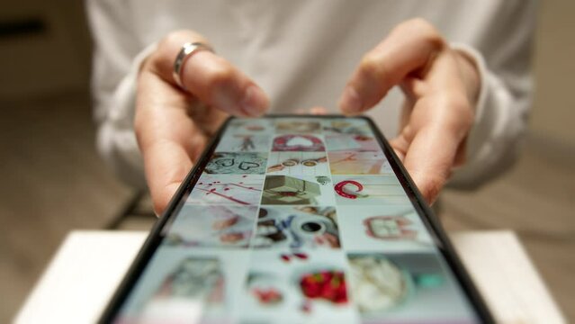 The close -up of the phone screen is viewing the photo gallery. The concept of social networks.
