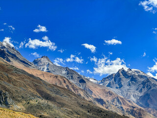 Landscape in high altitude mountains with clouds and blue sky