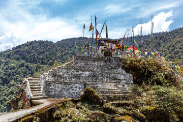 Naklejka premium Buddhist shrine with colorful prayer flags in the mountains of Bhutan, Asia