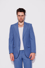 Fototapeta premium Stylish model in eyeglasses and vintage suit looking at camera in studio 