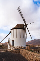 Traditional Windmill Against Mountainous Landscape: A Study in Architecture and Nature