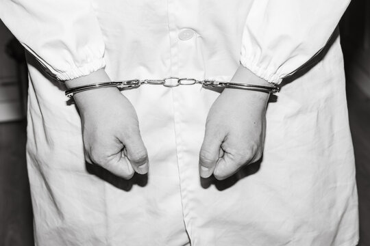 Doctor in handcuffs wearing Lab Coat