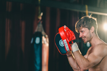 Active, athletes and fit men kick boxing and doing sport training workout in a gym. Two male partners or MMA boxer and trainer practice sparring exercises for a healthy wellness lifestyle.
