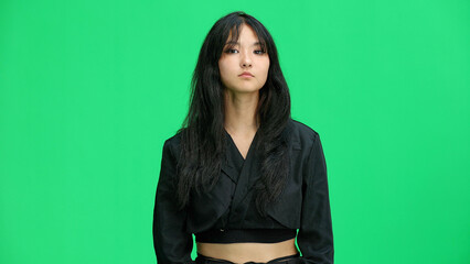 A girl in black clothes, on a green background, close-up