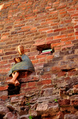 Toruń, figurka na tle ceglanego muru
