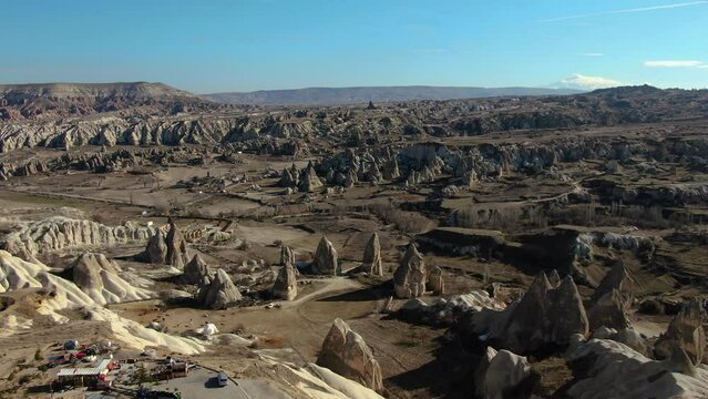 Sweeping aerial pan reveals the captivating beauty of Cappadocia's landscape, from fairy chimneys to unique rock formations.