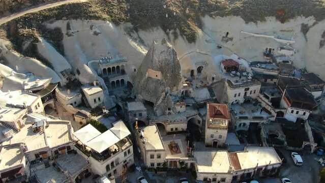 Descending slowly from above, a mesmerizing aerial view captures the charm of cave hotels in Cappadocia.
