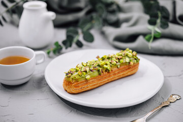 Sweet eclairs with dry pistachios on plate