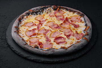 black dough pizza with cheese and ham