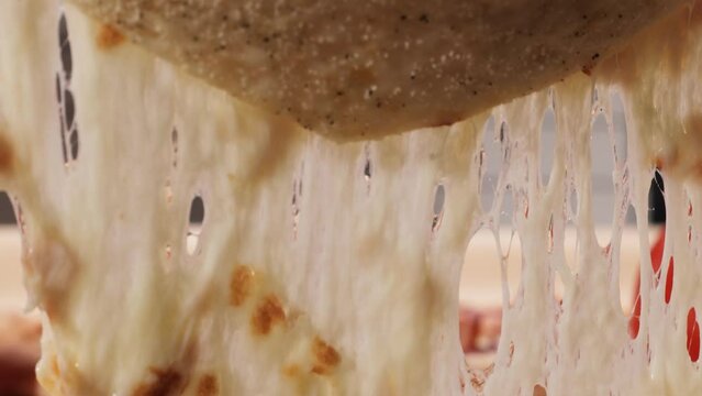A slice of pizza rises and the cheese stretches