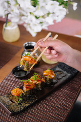 girl eats Japanese sushi gunkan salmon