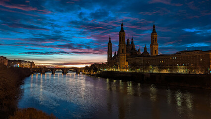 Fototapeta premium Sky on Fire: Radiant Sunrise in Front of the Majestic Basilica del Pilar in Zaragoza 