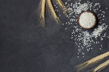 Glutinous rice in wooden bowl. Sprigs of cereals and sprinkled rice on table - obrazy, fototapety, plakaty