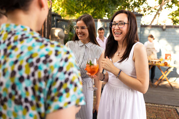 Group of beautiful happy people communicating and smiling while spending time on weding outdoors...