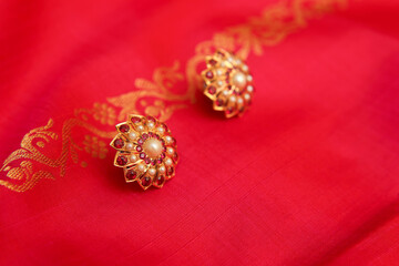 Indian traditional pearl earrings on silk saree	
