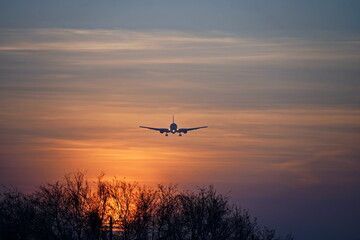 Fototapeta na wymiar The plane flies in the sky during sunset.