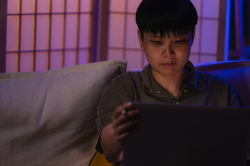 Late-night freelancer, Dedicated Asian woman working overtime on laptop computer, meeting deadlines...