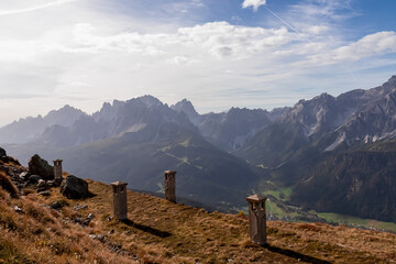 Remains of military bunker of First World War on mount Helm (Monte Elmo) with scenic view of mountain peaks of untamed Sexten Dolomites, South Tyrol, Italy, Europe. Wanderlust concept in Italian Alps - obrazy, fototapety, plakaty