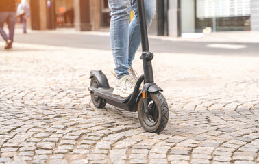 close up of woman legs in shirt  with electric scooter at the urban city bottom view People lifestyle concept © Iryna