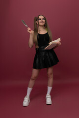 Woman writes in her notebook isolated on red background