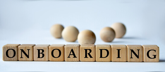 ONBOARDING - word on a wooden block on a white background with wooden balls