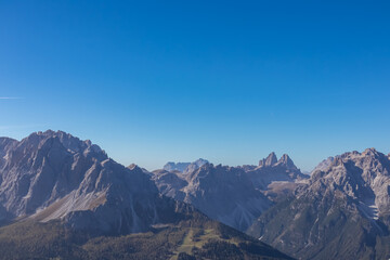 Scenic view of majestic mountain peaks of Tre Cime (Drei Zinnen) in untamed Sexten Dolomites, South Tyrol, Italy, Europe. Hiking concept Italian Alps. Blue clear sky. Looking from summit Hornischegg