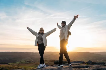 Fotobehang happy couple in love walking along countryside at the sunset.  Love, hiking and active lifestyle concept © Iryna