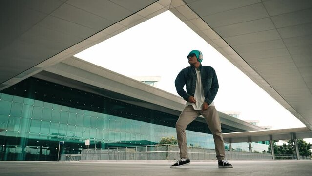 Panorama shot of happy hipster dance together while listen music from headphone at mall. Professional break dancer enjoy perform b boy footstep. Outdoor sport 2024. Modern street dancing. Sprightly.