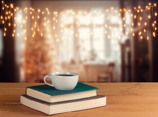 Cup tea with book in the room with glowing lights