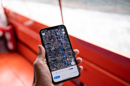 BANGKOK, THAILAND - JUL 15, 2022: Hand holding phone with waze navigation in Bangkok City