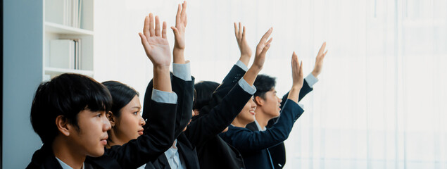 Business team or office workers raising their hands in seminar or business workshop training to ask...