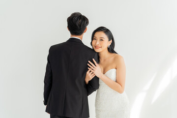 Love and commitment reflected in the smiles of an Asian couple as they present their wedding ring....