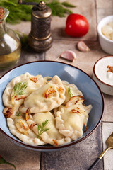Dumplings, pierogi or vareniki with potato or meat filling. Served with dill, roasted onion and...